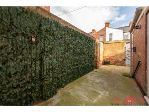 a wall covered in green ivy next to a alley at Darlington Modern 2 Bed Apartment Great for Contractors in Darlington