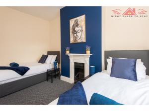 two beds in a room with a fireplace at Darlington Modern 2 Bed Apartment Great for Contractors in Darlington