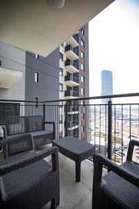 a balcony with chairs and tables on a building at Bw Lux Apartments - Beograd na Vodi in Belgrade