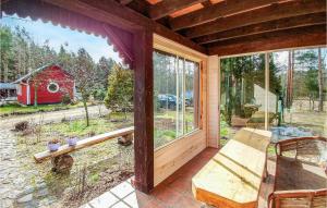 a screened in porch with a view of a red barn at 3 Bedroom Awesome Home In Legbad in Legbąd