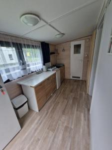 a kitchen with wooden floors and a white counter top at Leśny Zakątek - Domek Morze in Ustka