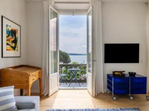 a living room with a sliding glass door leading to a balcony at Beccherie 90 in Verbania