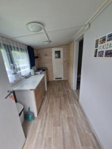 a kitchen with wooden floors and a white refrigerator at Leśny Zakątek - Domek Morze in Ustka +5 photos