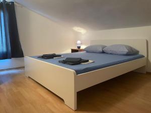 a bedroom with a bed with blue sheets and pillows at Apartments Vozab in Pag