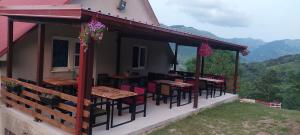 a patio with tables and chairs on a house at Etno selo -ŠAPAT- in Šavnik