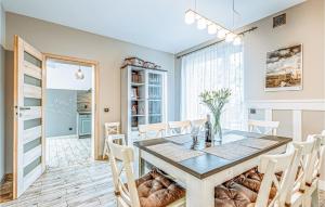 a dining room with a table and chairs at 5 Bedroom Stunning Home In Grzybowo in Grzybowo +21 photos