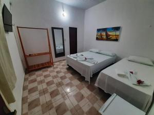 a room with two beds and a mirror at Jangaloa in Jijoca de Jericoacoara