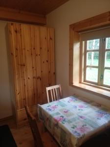 a bedroom with a bed and a window and a table at Chatka Na Rozdrożu in Uście Gorlickie