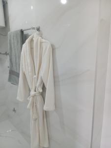 a white robe hanging on a towel rack in a bathroom at Apartmani Mušinbegović in Visoko
