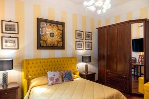 a bedroom with a bed with a yellow headboard at Regal House Anzio Manetti 16 in Anzio