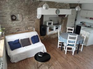 un salon avec un canapé blanc et une table dans l'établissement Ti an traõn le petit gîte en cœur de Bretagne, à Carhaix-Plouguer