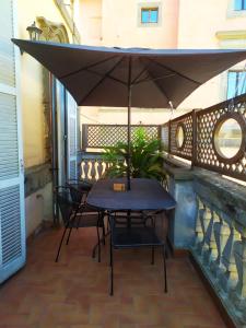 un tavolo e delle sedie sotto un ombrellone in un patio di Ecco Marino Casa Vacanze a Marino