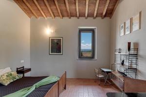 モンテカティーニ・ヴァル・ディ・チェーチナにあるHigh-quality Villa with private pool San Giuseppe Maestraleのベッドと机と窓のある寝室
