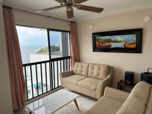 a living room with a couch and a view of the ocean at Apartamento Los Laureles Rodadero in Santa Marta