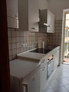a kitchen with white cabinets and a sink at CASA DONATELLA a pochi passi dal mare in Levanto