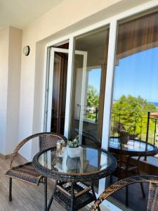 a patio with a glass table and chairs on a balcony at Summer Apart Janet in Obzor