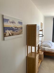 a bedroom with a bed and a painting on the wall at T2 vue sur le port jacuzzi terrasse et parking in Carry-le-Rouet