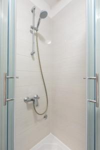 a shower with a shower head in a bathroom at Casa la Mare - Krk Town in Krk +28 photos