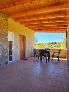 a patio with a table and chairs and a stone wall at Complejo Falda del Sauce in Villa General Belgrano +84 photos