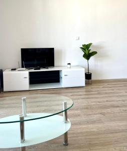 a living room with a tv and a glass table at Summer Apart Janet in Obzor