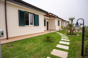 Marina di AsceaにあるVS Le Terrazze degli Dei - Villa con giardino, palestra, area giochi per bimbiの芝生の庭と街灯のある家