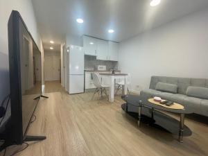 a living room with a couch and a tv and a table at Céntrico apartamento muralla 2 in Lugo