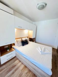 a bedroom with a large bed with white cabinets at Summer Apart Janet in Obzor