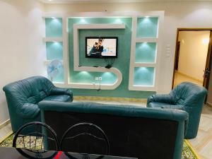 a living room with two blue couches and a tv at MK Hebergement in Saint-Louis