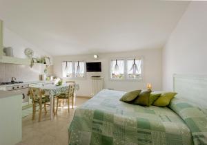 a bedroom with a large bed and a kitchen at Agriturismo Le Girandole in Diano Marina