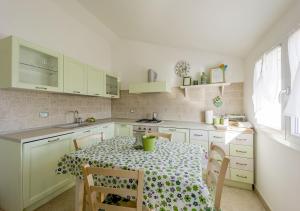 a kitchen with a table and chairs and a kitchen with white cabinets at Agriturismo Le Girandole in Diano Marina