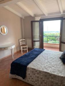 a bedroom with a bed and a table and a window at La villa di Turi in Castellammare del Golfo