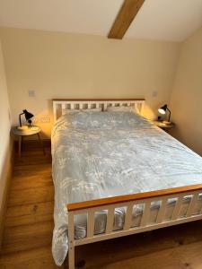 a bedroom with a bed with a white comforter at Dovecot in Altarnun