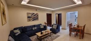 a living room with a blue couch and a table at سجى الهدوء للشقق المخدومة in Abha