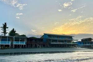 a row of houses on a beach with the ocean at Casa Esmeralda in Colán +9 photos