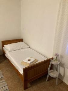 a bedroom with a bed with a table and a chair at Vila Klara room - garden view in Olib