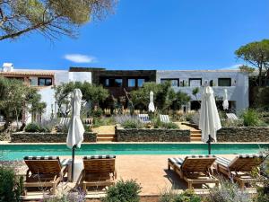 ein Resort mit einem Pool, Stühlen und Sonnenschirmen in der Unterkunft Boutique Hotel Villa Salvador - Adults Only by Fimedhotels in Cadaqués