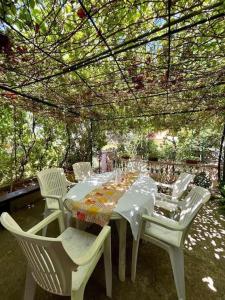 a white table and chairs under a pergola at Vila Klara room - garden view in Olib +35 photos