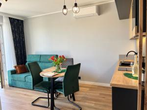 Una sala de estar con una mesa y un sofá azul. en Apartament Happy, en Busko-Zdrój 10 fotos más