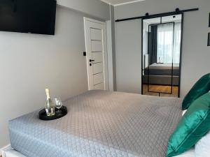 Un dormitorio con una cama con una botella y vasos. en Apartament Happy, en Busko-Zdrój