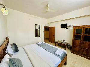 a bedroom with a bed and a tv on the wall at Hotel Empire Palace in Udaipur