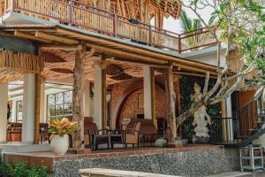 a resort with a deck and chairs on a patio at Putri Ayu Cottages in Ubud