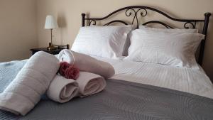 a bed with towels and pillows on it at Medusa Myrina Luxury Apartments 1st Floor in Myrina
