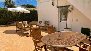 a patio with a table and chairs and an umbrella at Casa dos Arcos in Olhos de Água