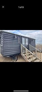 a blue trailer with a porch on the beach at A Snuggles hut in Faversham