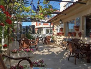 an outdoor patio with chairs and tables and flowers at Hotel Vasco Da Gama in Sabaris