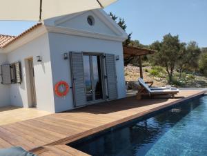 a villa with a swimming pool next to a house at Costa Meganisi in Meganisi