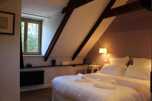 a bedroom with a bed with two towels on it at Manoir du Moustoir - Hôtel Les Empreintes in Saint-Évarzec