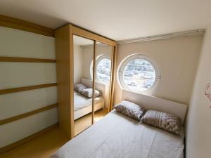 a small room with a bed and a mirror at Cozy studio with pool close to the sea in Ostend
