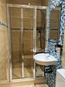 a bathroom with a shower and a sink at Lidos Hotel in London +17 photos