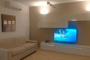 a living room with a couch and a flat screen tv at La casa smart zona stadio in Terni